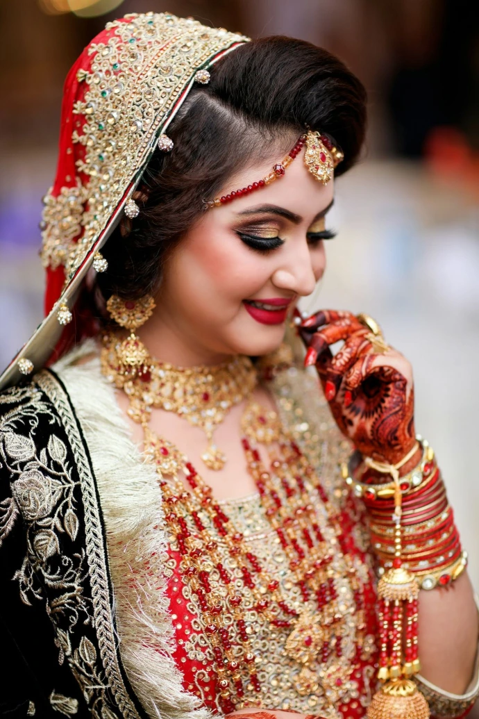 a woman in a red and gold bridal outfit